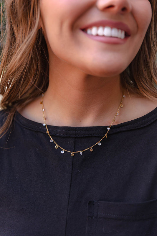 Dainty gold charm necklace styled with black top