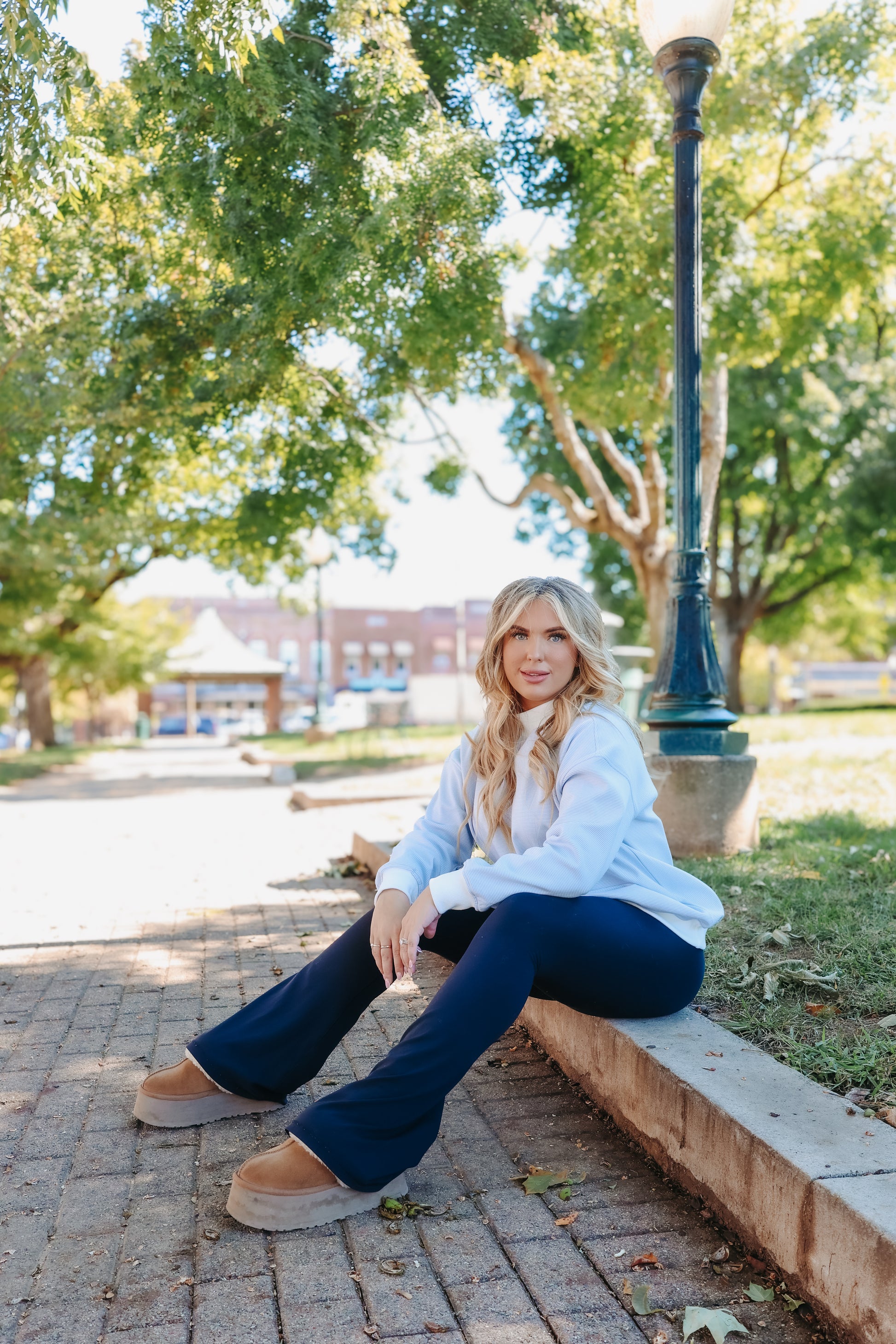 Model wearing blue and white striped mock neck top.
