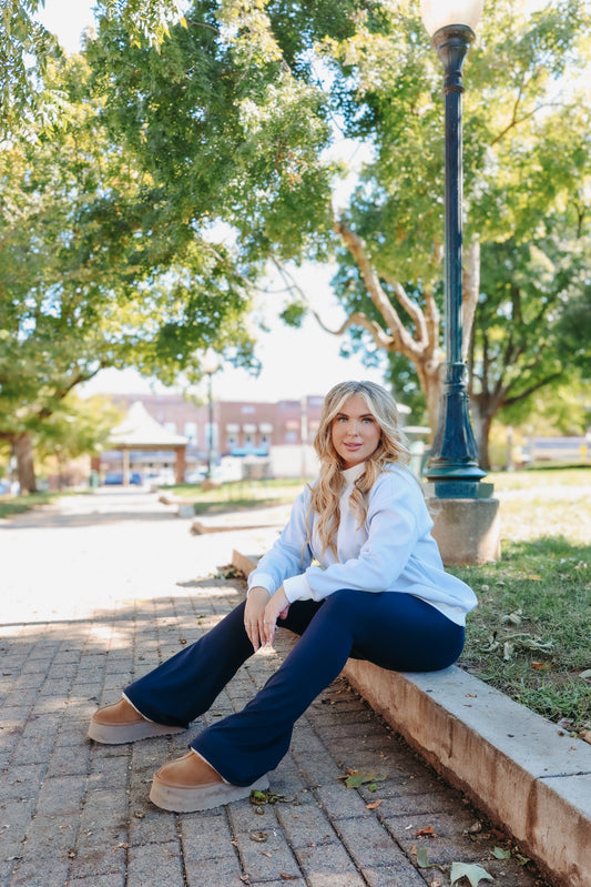 Model wearing blue and white striped mock neck top.